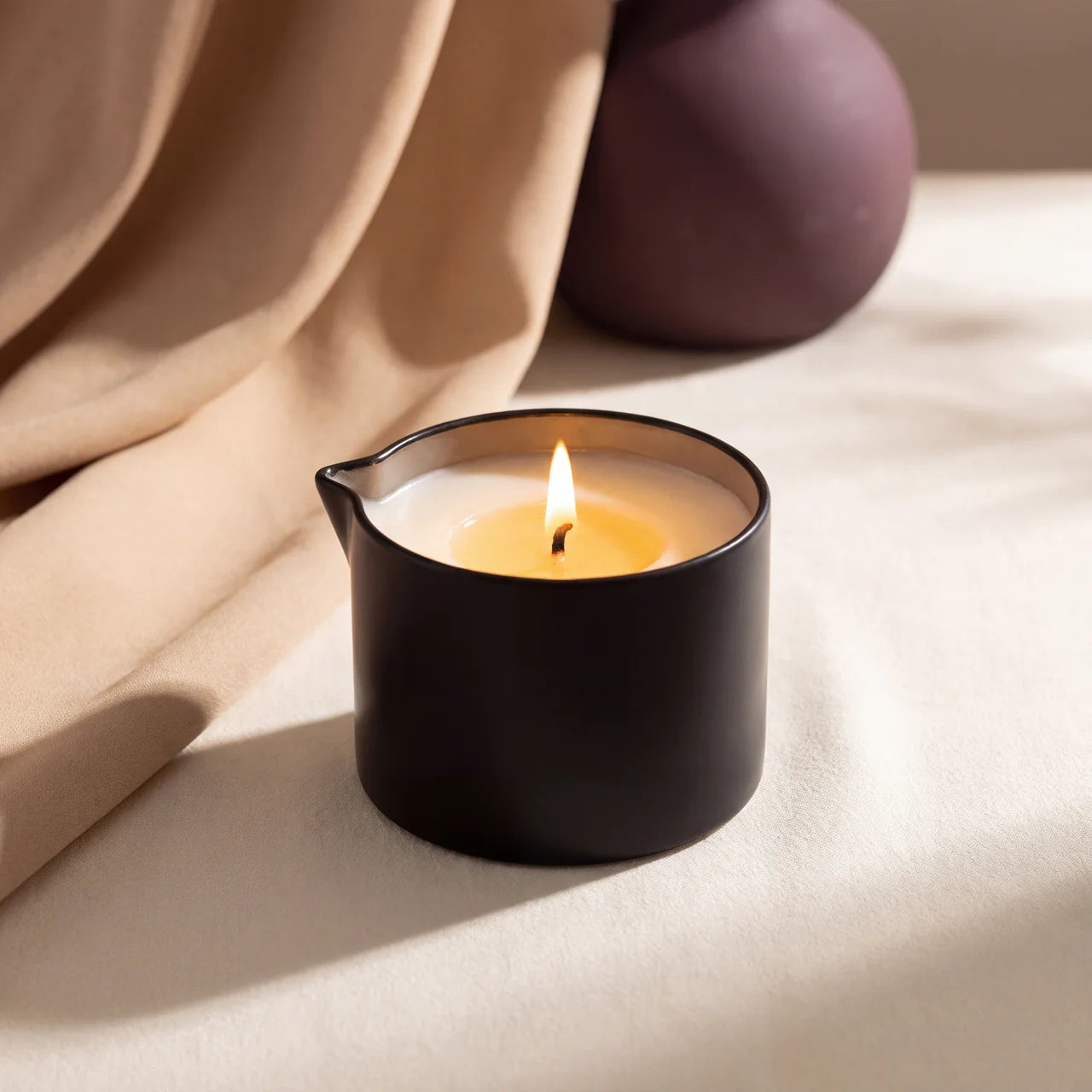 Lit CareHush candle with a warm pool of oil