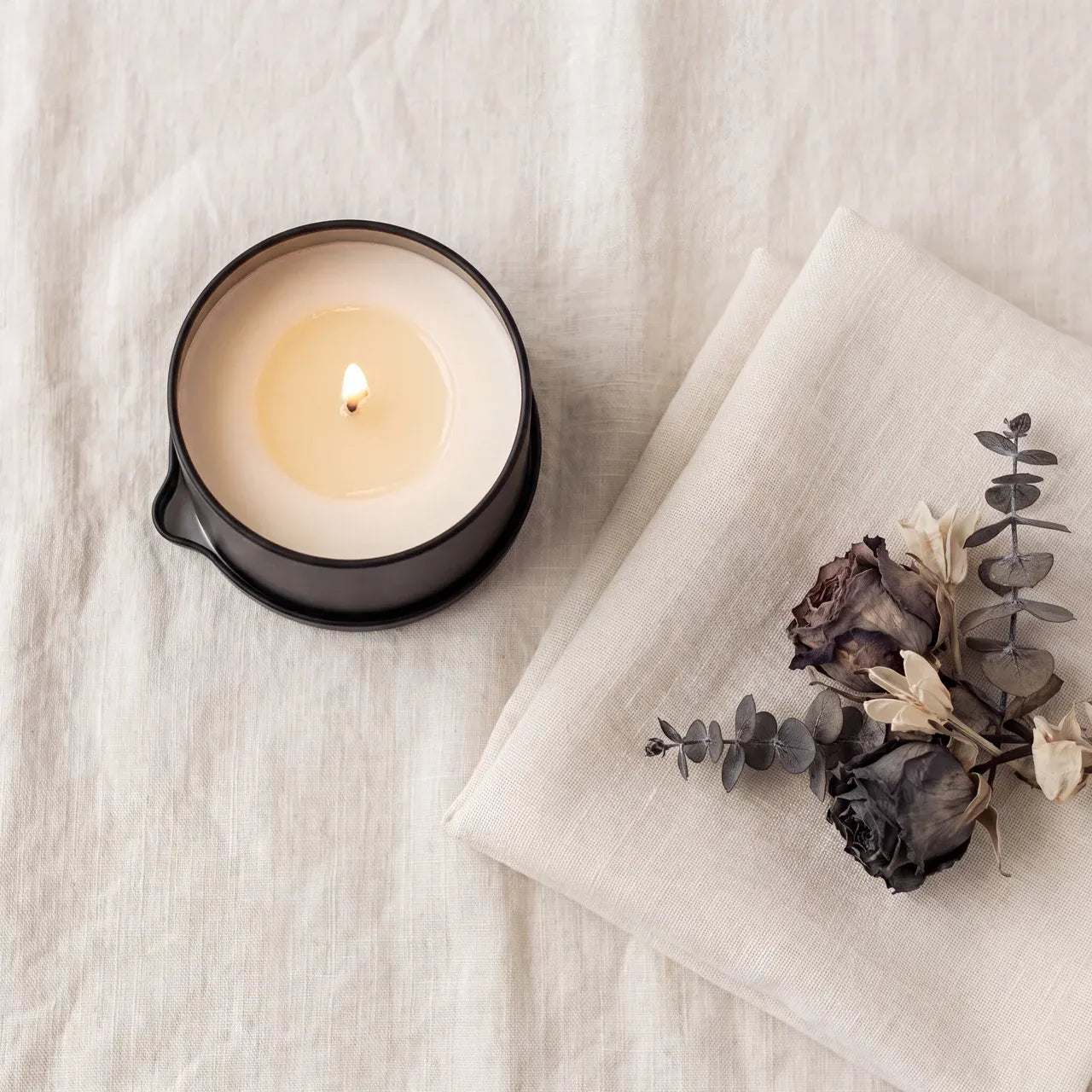 CareHush massage candle in a calm linen setting